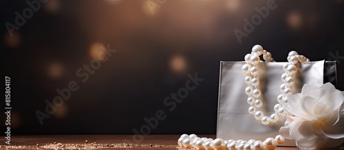 A gift bag adorned with elegant pearls sits alone providing ample copy space for showcasing its beauty