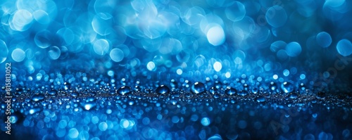 Blue glitter sparkles on a dark blue background.
