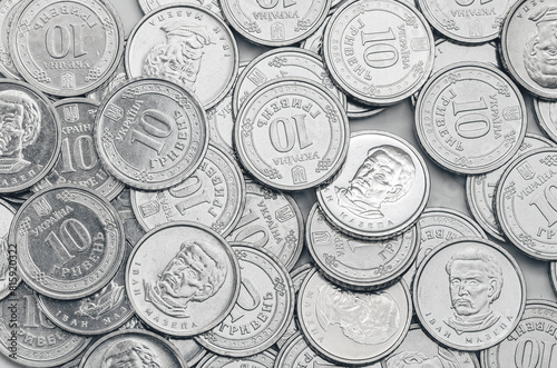 Ukrainian money, exchange coin, white coins denomination of 10 hryvnias in random order. Top view..