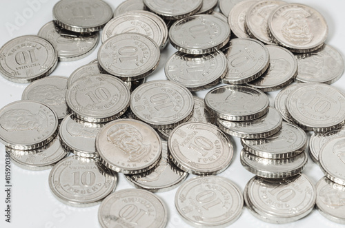 Ukrainian money, exchange coin, white coins denomination of 10 hryvnias in random order. Macro.