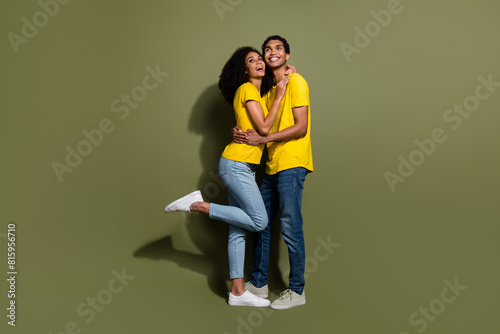 Full body portrait of two nice people cuddle look empty space wear t-shirt isolated on khaki color background