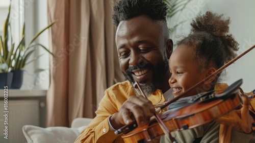 Father and daughter enjoying time together as he teaches her how to play the violin in a cozy home setting.