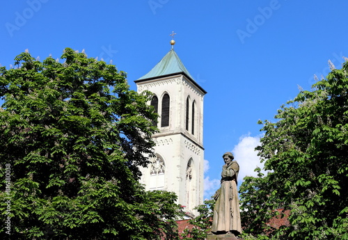 Turm der Martinskirche in Freiburg zwischen blühenden Kastanien