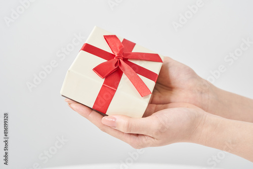 プレゼント用に包装された箱を持つ女性の手元