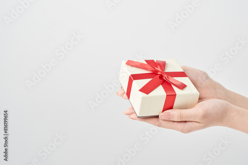 プレゼント用に包装された箱を持つ女性の手元