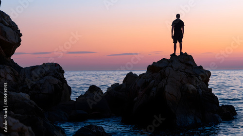 Silhouette of a man on some rocks on the coast of the Costa Brava in the province of Gerona in Spain during sunset : Generative AI