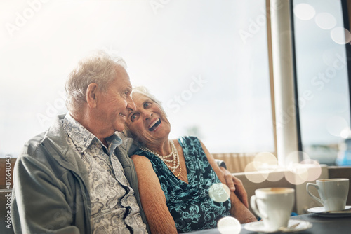 Happy, elderly couple and laughing on coffee date in restaurant for bonding, comedy and funny joke in retirement. Smile, senior man and woman with bokeh and morning espresso for relax and humour