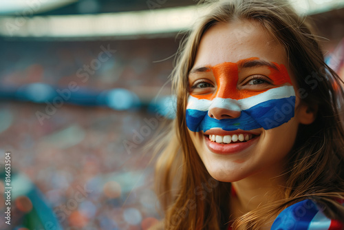 Spanish soccer fan woman with national flag of spanish painted on her face. Celebrating crowd in a stadium. Cheering during a match in stadium