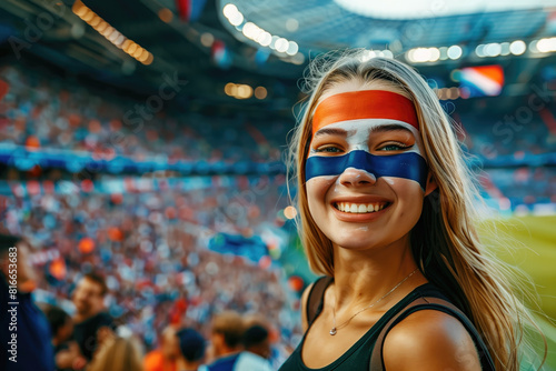 Spanish soccer fan woman with national flag of spanish painted on her face. Celebrating crowd in a stadium. Cheering during a match in stadium