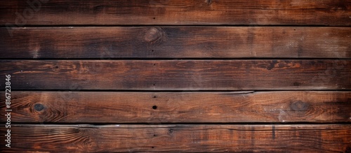 Copy space image of a vintage brown wooden background with visible knots and nail holes resembling an old painted wood wall The horizontal dark boards create an abstract and vintage atmosphere Perfec