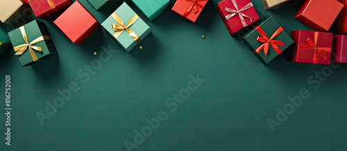 A festive greeting card showcasing gift boxes arranged on a vibrant green and red background The top down perspective provides copy space making it perfect for expressing Merry Christmas and Happy Ne
