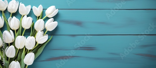 Flowers composition Delicate white tulip flowers and many small bloks with colorful hearts on blue wooden background Many small blocks with colorful hearts Valentine s day women s concept