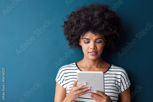 African woman, tablet and space in studio for mockup with reading on app, study or quiz by blue background. Person, girl and student with digital touchscreen, online course or elearning for education