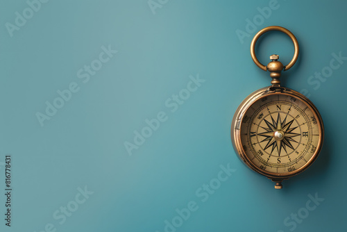 A high-resolution photo of a vintage compass on a solid blue background 