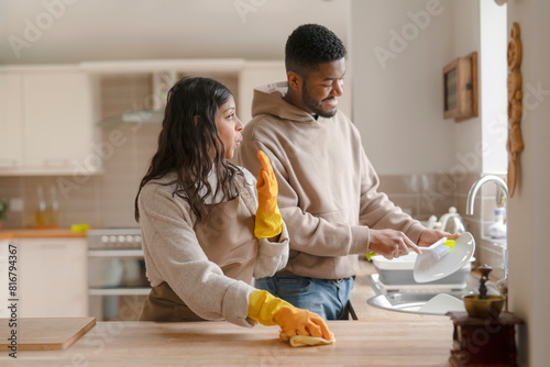 man and woman cleaning kitchen together at home