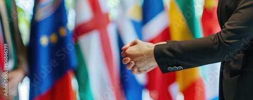 Two diplomats shaking hands with various flags in the background. This image symbolizes international cooperation and diplomacy, highlighting diverse cultural and national representations.