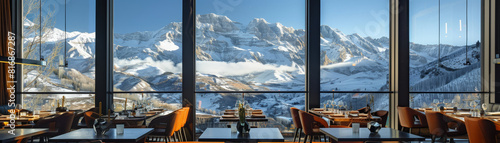 An upscale restaurant featuring floor-to-ceiling windows offering a breathtaking evening view of mountains and city lights.