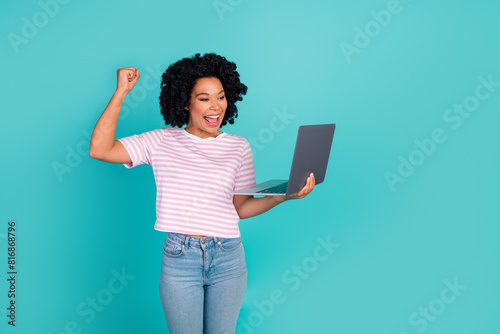 Photo portrait of lovely young lady hold netbook winning dressed stylish striped garment isolated on aquamarine color background