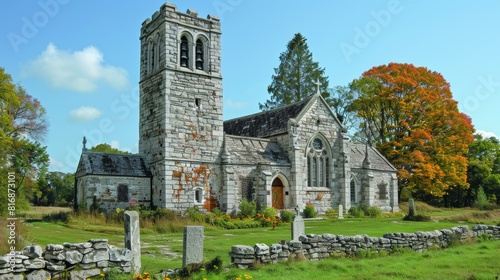 A picturesque, historical stone church with a tall bell tower, surrounded by vibrant autumn foliage and set in a serene, lush green meadow, creating a tranquil and timeless scene