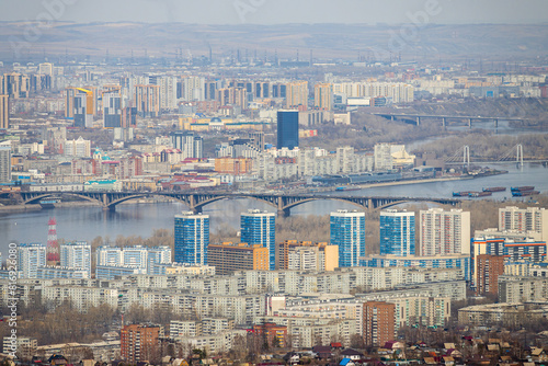 Krasnoyarsk city, Krasnoyarsk region, Siberia, Russia. Big Siberian city. View of many buildings and a road bridge across the Yenisei River.