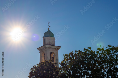 Church Tower of San Zenone Against Blue Clear Sky and Sunbeam in Campione d'Italia, Lombardy, Italy.