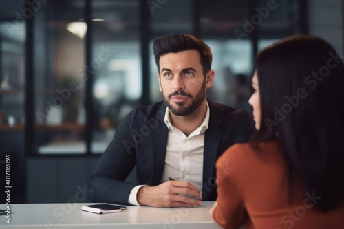 portrait of a handsome man leaning over the table talking to his female colleague at work