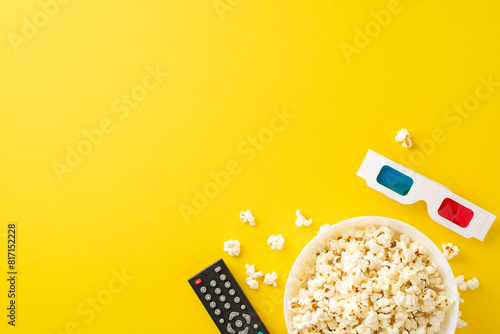 Home theater vibes: top view of popcorn, 3D glasses, and remote control for streaming. Ideal for promotions or personalized messages against bright yellow