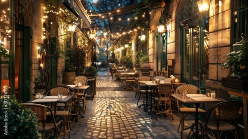 A charming outdoor cafe with empty tables and chairs, lit by string lights, in a narrow European alleyway during dusk.