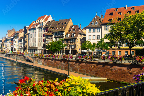 Peaceful cityscape of Strasbourg during summertime. Streets and canals of French city decorated with colorful flowers.