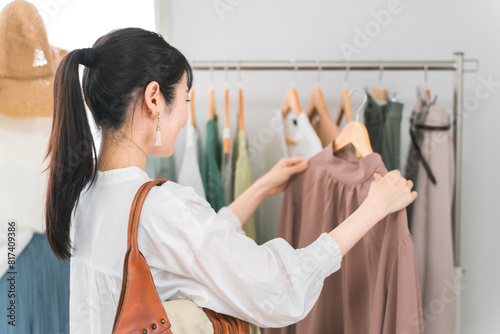 アパレルショップで洋服を買い物・ショッピングする女性 