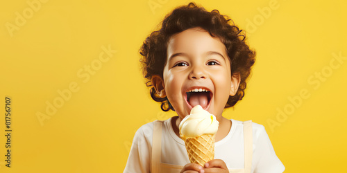 A toddle enjoy eating ice cream with cone against yellow background.