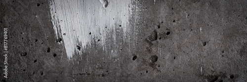 Texture of old concrete wall. Rough grey surface of concrete with a white smear of paint. Wide panoramic background for design.