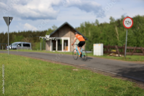 Rowerzysta na drodze w górach, dron w powietrzu.