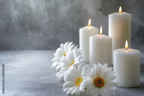 Tranquil condolence background featuring lit white candles and fresh white daisies on a textured grey surface, symbolizing remembrance and peace