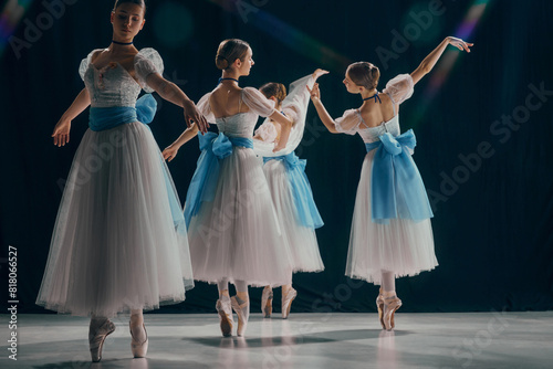 Portrait of four young ballerinas, posing in graceful positions, dressed in delicate white tutus with blue accents. Movement. Concept of beauty, classic and modernity, contemporary art. Ad