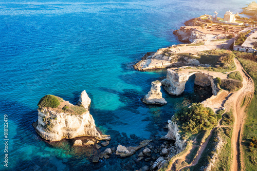 Stunning seascape with cliffs rocky arch and stacks (Faraglioni) at Torre Sant Andrea, Salento coast, Puglia region, Italy. Beautiful cliffs and sea stacks of Sant'Andrea, Salento, Apulia, Italy