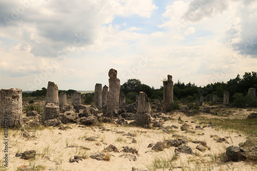 A group of stone pillars rising from a desert-like landscape at the Pobiti Kamani stone forest near Varna, Bulgaria