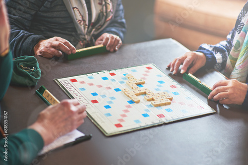 Board game, table and senior people playing in nursing home for retirement and friendly contest. Crossword, puzzle and battle of elderly woman in house winning with strategy, choice and challenge