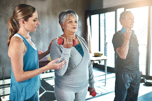 Physical therapy, dumbbell and senior people in support, help and muscle workout for recovery or health. Exercise, fitness and strength progress of elderly clients in physiotherapy or wellness class