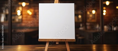A small canvas rests on an easel placed on a wooden table offering ample room for adding images or text