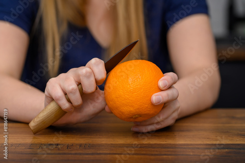 Kobieta obiera pomarańcze małym nożykiem słodka przekąska 