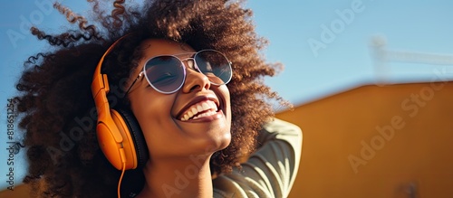 A cheerful young black hipster girl with stylish glasses enjoys her free time outdoors creating a copy space image for positive advertising text