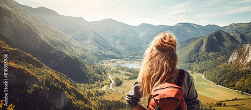 Copy space image of a cheerful teenage girl with a backpack experiencing joy while gazing at the scenic mountain view This background represents the concept of a summer vacation hike