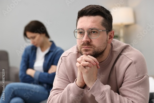 Offended couple ignoring each other after quarrel in bedroom, selective focus. Relationship problems