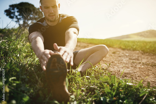 Runner, grass or man stretching legs for training, exercise or fitness workout in countryside nature. Muscle warm up, healthy or sports athlete ready to start practice for wellness, body or running