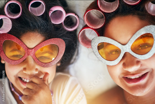 Mother, girl and portrait on bed with rollers for love, fun and hair care together at home. Woman, daughter and silly glasses in bedroom for bonding, excitement and pampering for special day