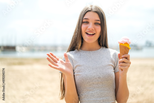 Teenager girl with a cornet ice cream at outdoors with shocked facial expression