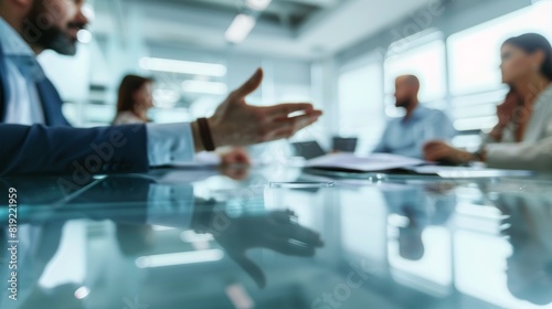 Colleagues in a business meeting, focused on hand gesture with blurred coworkers around.