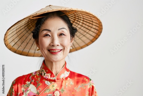 Portrait of a smiling Chinese woman wearing a traditional silk robe and conical hat, white background