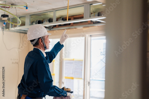 工事中の現場で指差し確認をする職人